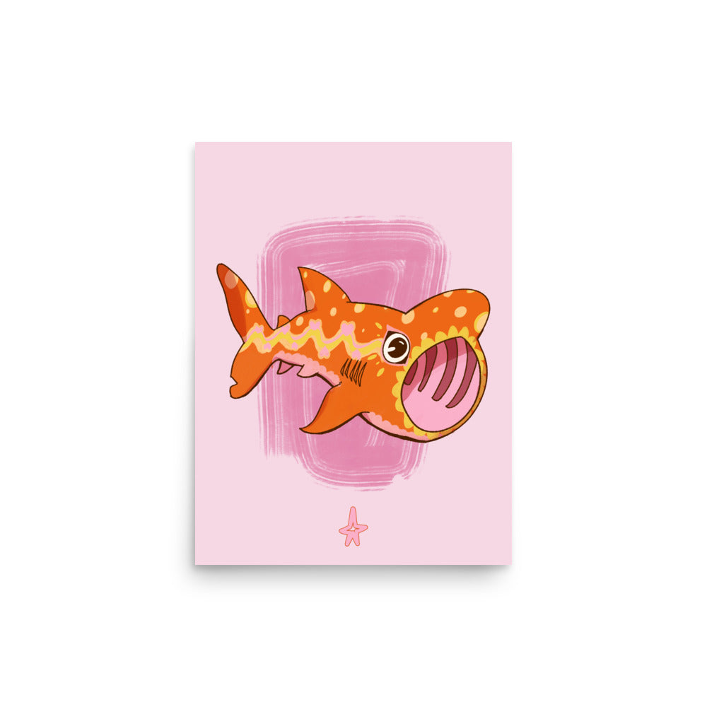 Framed illustration of a cartoon shark on a pink background, displayed on a wooden cabinet.
