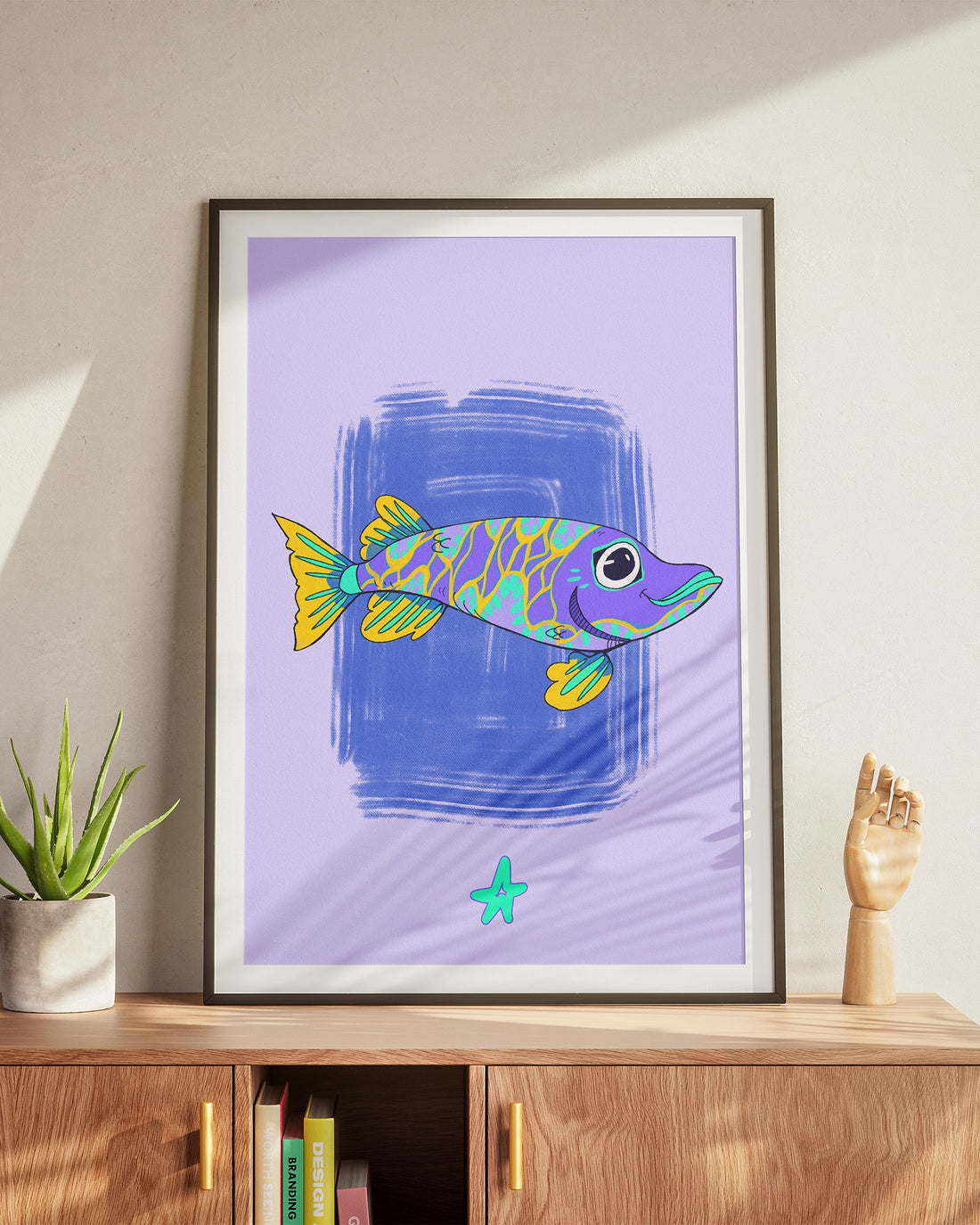 Framed artwork of a colorful fish on a wall above a wooden cabinet.